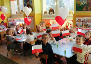 Dzieci prezentują samodzielnie wykonane flagi biało- czerwone